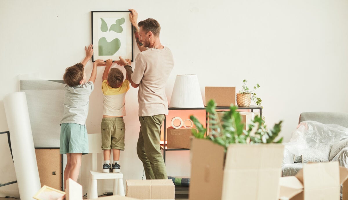 Vater mit zwei Söhnen beim Einzug in die neue Wohnung