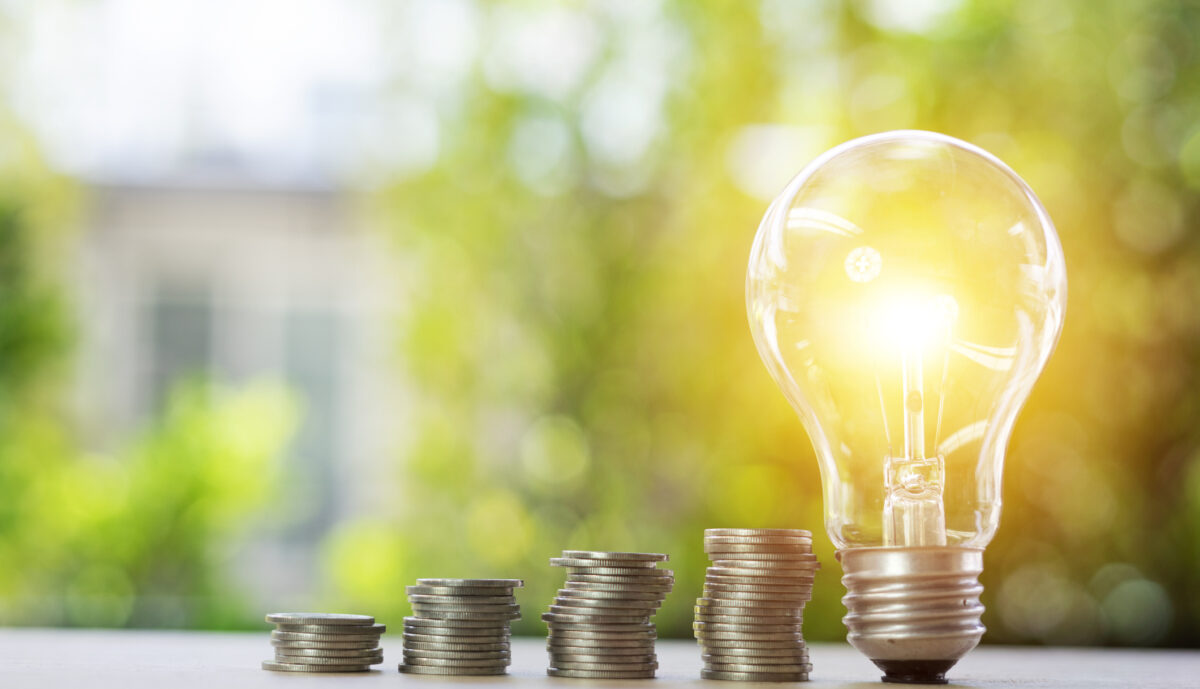 Glühbirne und Münzstapel als Symbol für Energiesparen